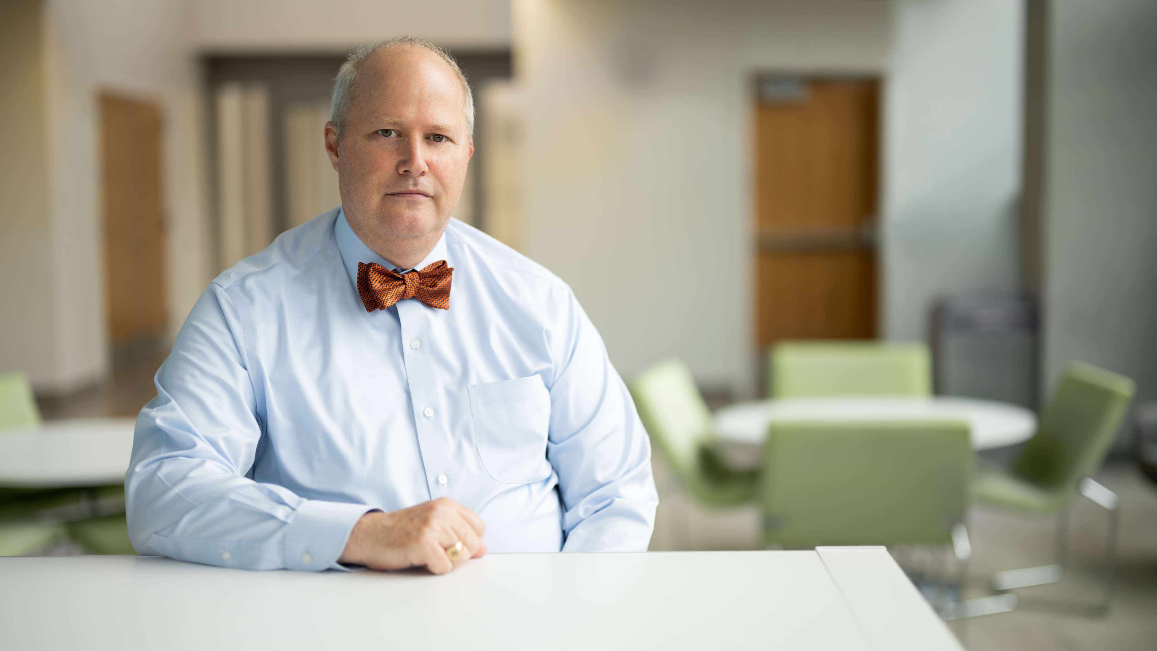 portrait of man in blue shirt and red bowtie in office setting
